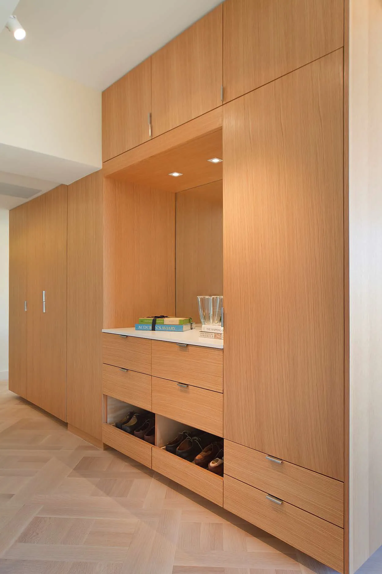 Built-in wood cabinetry with an illuminated niche, drawers and shoe storage on the Upper East Side