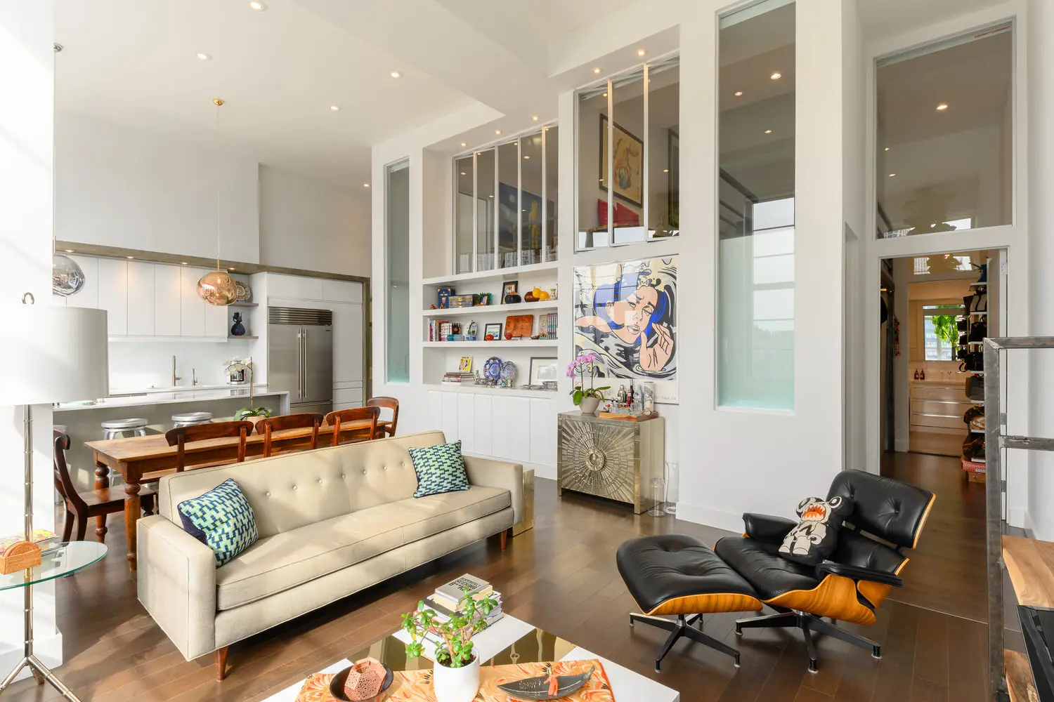 Arris Lofts II living room in Long Island City with a cream sofa, wood flooring and tall glazed partitions beside built-in shelves