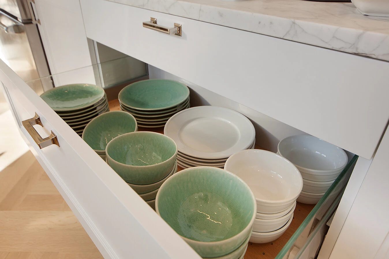 Deep kitchen storage drawer holding stacked plates and bowls in an Upper East Side apartment