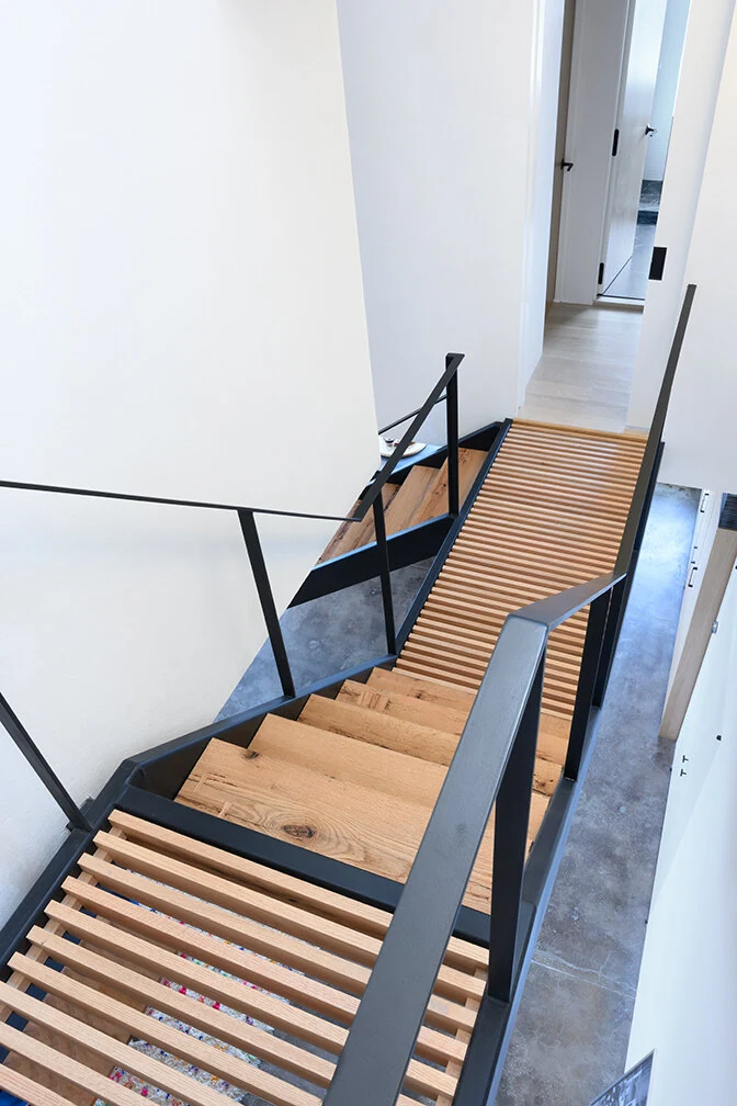Wood stair treads and slim black railings viewed from above in Williamsburg