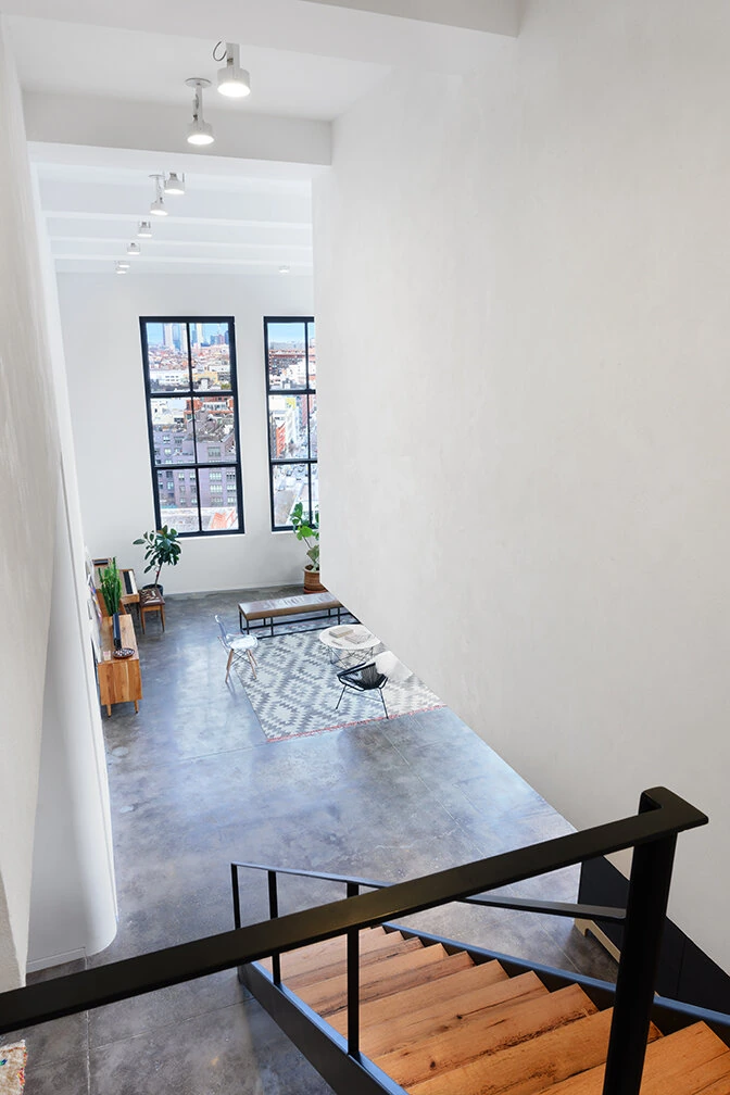 Upper landing overlooking the bright living room in a Williamsburg loft