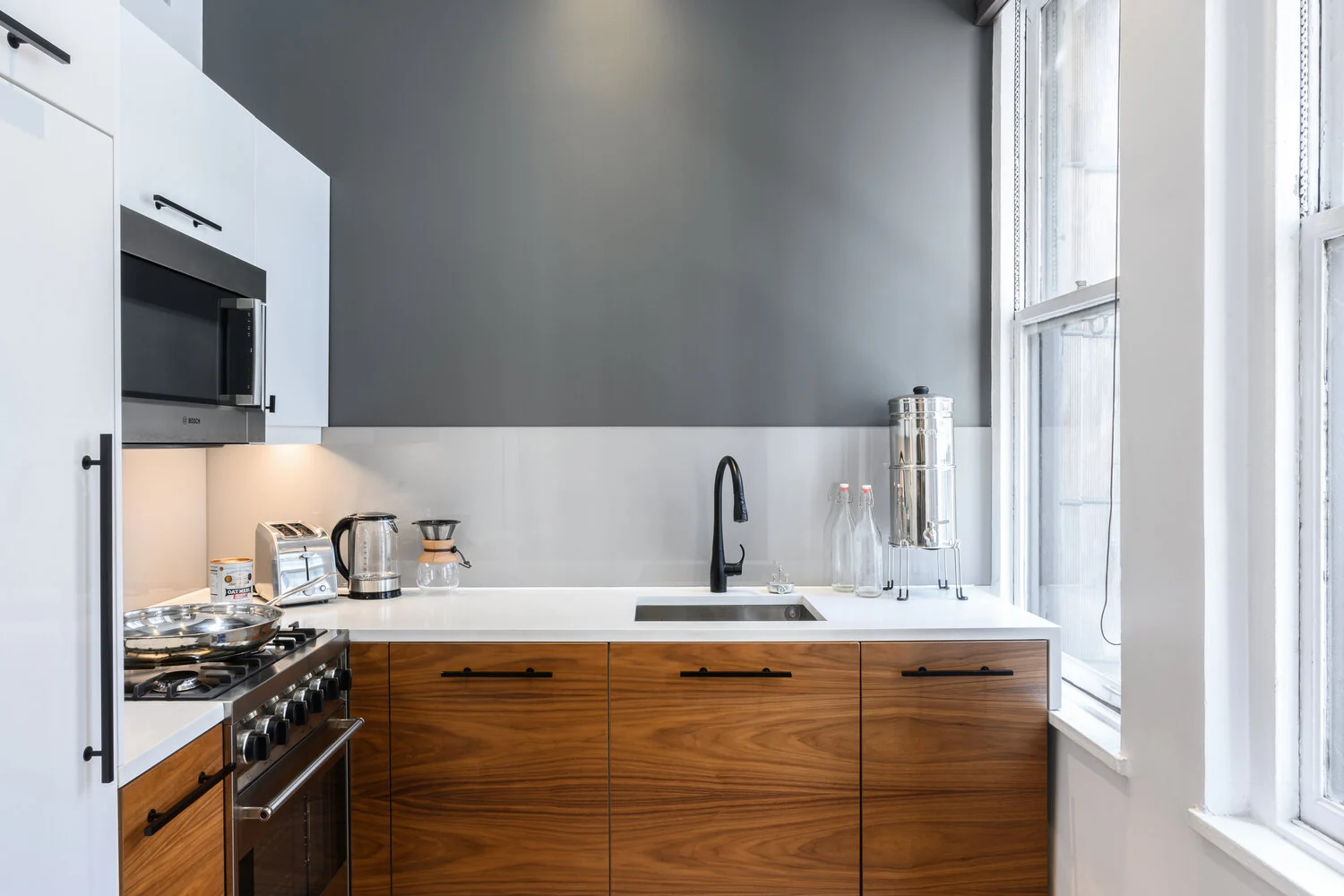 Lexington kitchen in New York City with wood cabinets, a white countertop, black faucet and stainless steel range