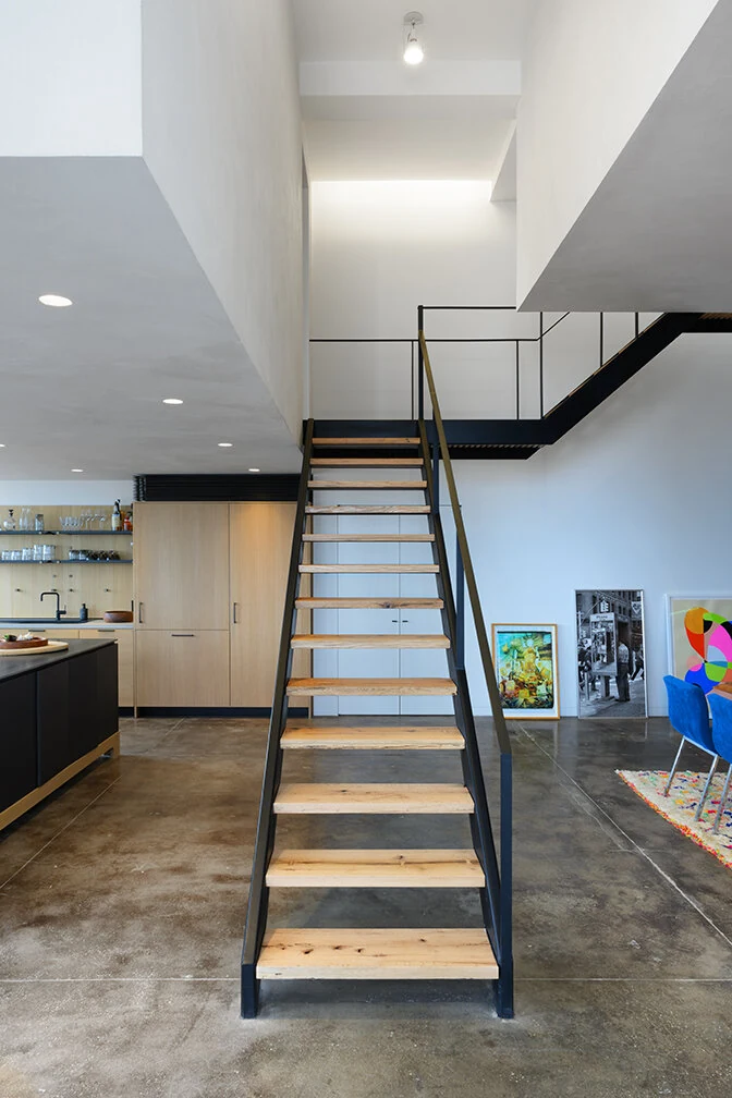 Open wood and black metal staircase beside the kitchen in Williamsburg