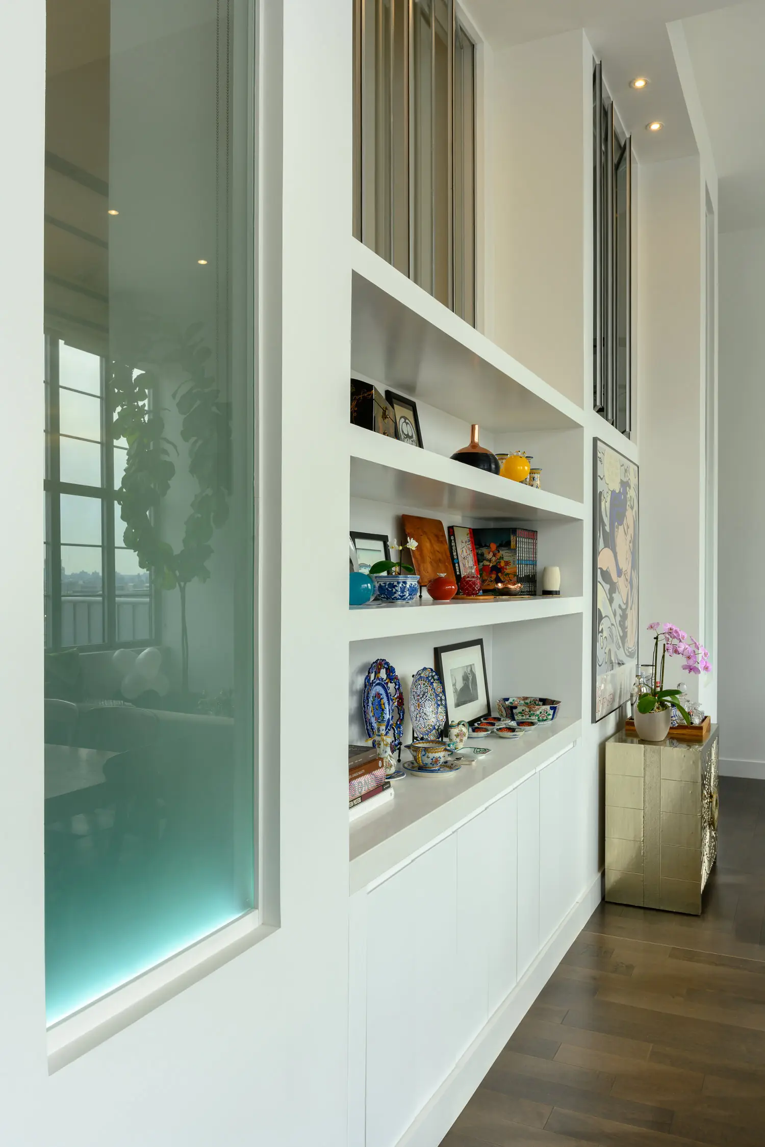 Close view of white display shelves and tall glass partition panels at Arris Lofts II in Long Island City, New York