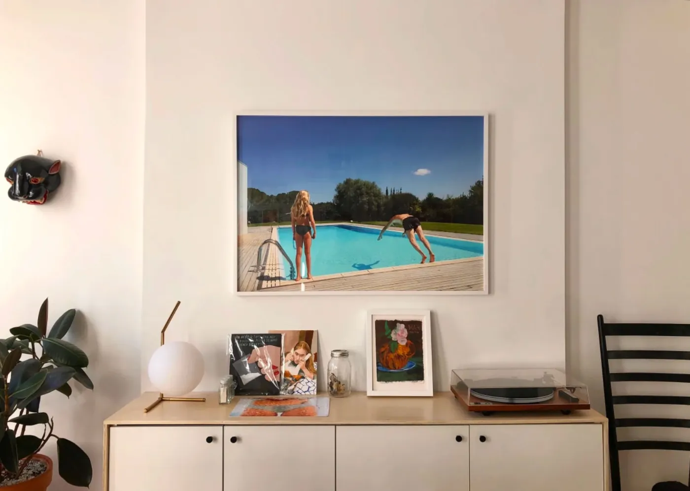White credenza with light wood frame styled under framed art in a renovated NoHo apartment