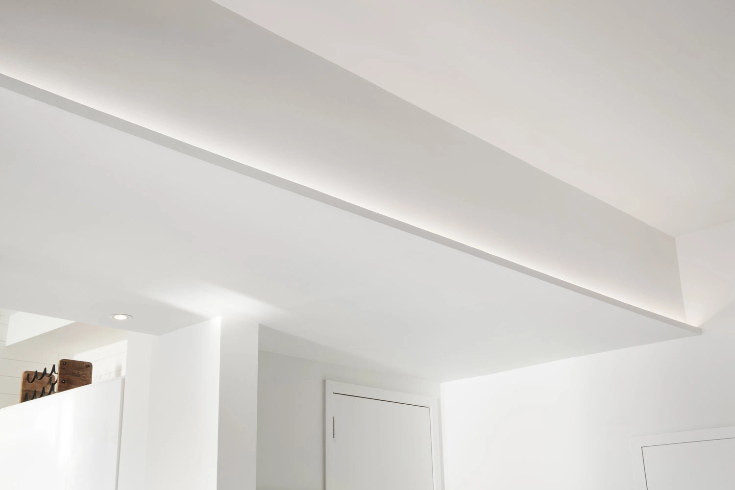 Concealed ceiling lighting along a white soffit above the doorway in a CityLights apartment in Long Island City
