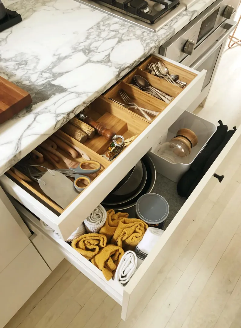 Organized kitchen drawers beneath a marble countertop in a renovated NoHo apartment