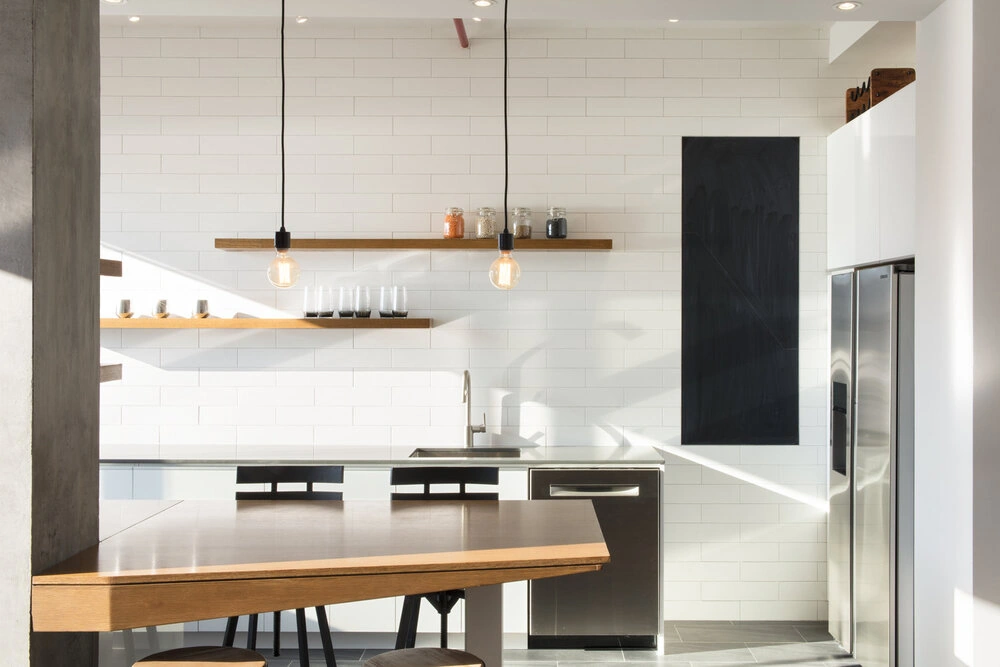 CityLights kitchen in New York with white cabinetry, stainless steel appliances and wood shelves above the sink