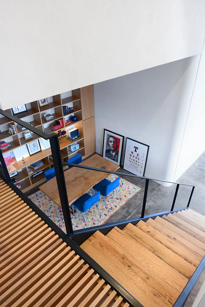 View down the open staircase toward shelving and living space in Williamsburg