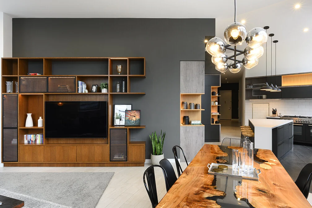 Wood media cabinetry against a dark accent wall at Arris Lofts in New York, beside the open kitchen and dining area
