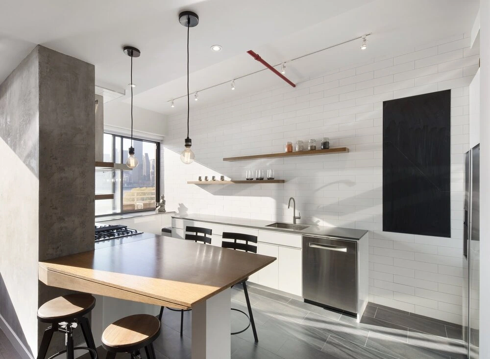 CityLights kitchen in Long Island City, New York with a wood counter, white tile walls, open shelves and pendant lights