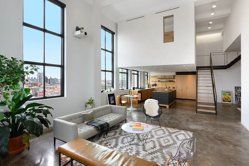 Open living room with tall windows, an open kitchen and mezzanine in Williamsburg, Brooklyn