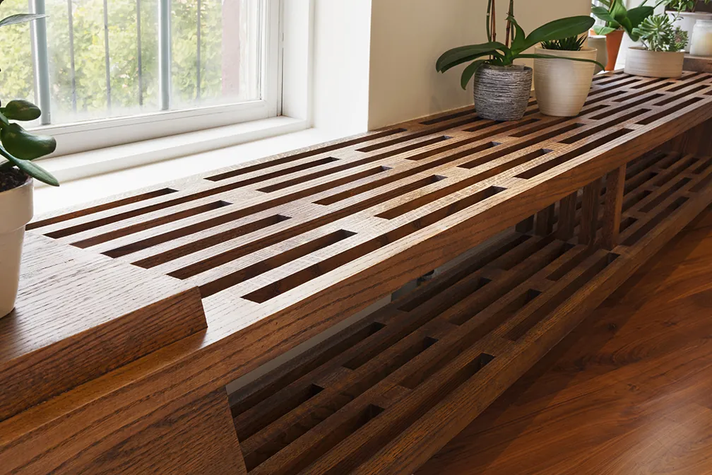 Custom slatted wood bench built along a window in a Greenwich Village apartment by MELDNYC