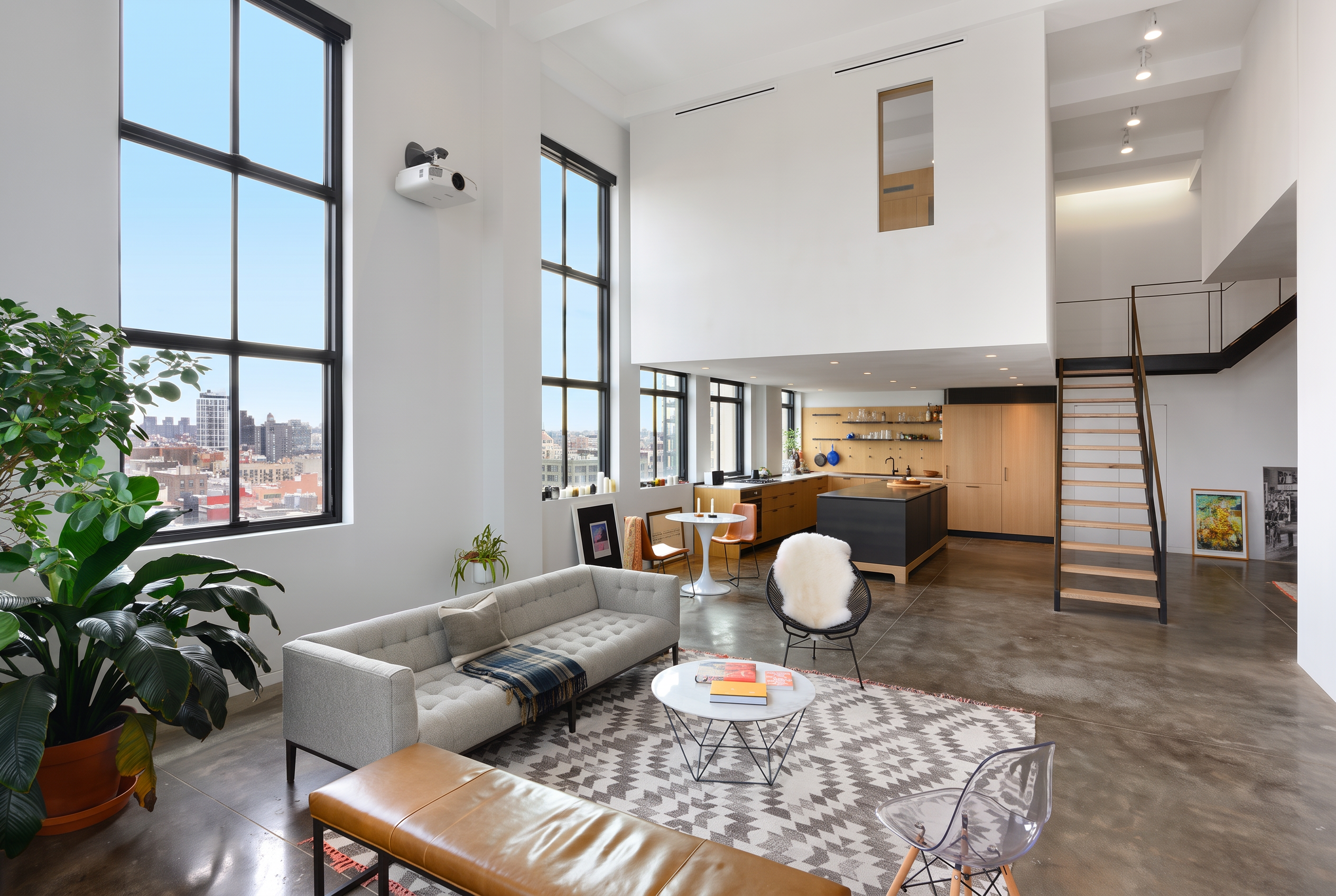 Open living room with tall windows, an open kitchen and mezzanine in Williamsburg, Brooklyn